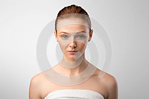 Lady Wrapped In White Towel Posing Over Gray Studio Background