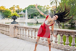 Ladyboy tattooed transgender model is dancing in the green park