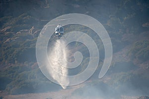 A LAFD Bell 206 helicopter makes a water drop on a brush fire in Chatsworth, CA