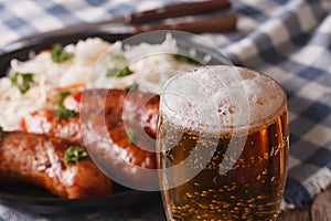 Lager beer close-up on a background of snack sausages and sauerkraut.