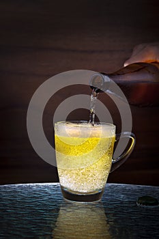 Lager beer drain from bottle to glass on table