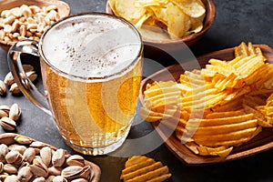 Lager beer and snacks on stone table