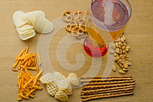 Lager beer and snacks on table. Nuts, chips, pretzel.