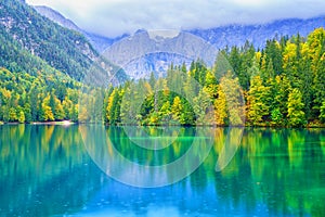 Laghi di Fusine inferior lake, Tarvisio, Italy. Autumn landscape with water, forest and Mangart mountain, nature travel background