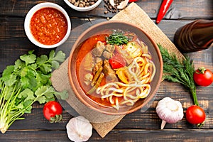 Lagman soup from middle Asia on dark wooden background photo