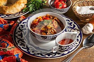 Lagman. Uzbek soup with noodles, lamb, vegetables, herbs and adjika photo