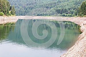 Lago di Paneveggio artificial lake surrounded by dense forest in Fiemme valley in Trentino, Italy