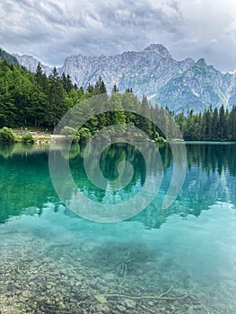 Lago Inferiore di Fusine beautiful reflections of the Julian Alps and the trees in the clear water