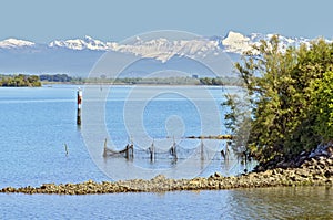 Lagoon of Grado and snow-covered Carnic alps