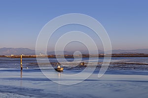 Lagoon of Marano Lagunare with fisherman boat at sunset. photo