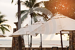 Lagre umbrellas on the sunset beach background.