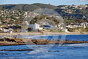 Laguna Beach, California tide pool exploring at Main Beach rocks with Hotel Laguna in background.