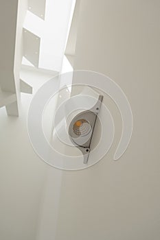 The laid on LED lamp of white color on a white wall