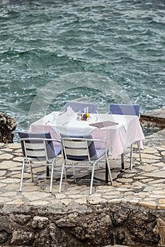 Laid table and chairs at a restaurant by the sea
