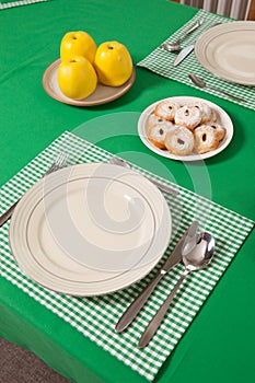 Laid table - fork and spoon laid on green cloth and white plate