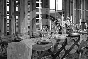 Laid Table By wedding banquet in a wooden barn.