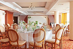 Laid wedding table with glass goblets and flowers on a colored carpet