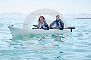 Laidback and enjoying themselves out on the lake. Portrait of a young couple kayaking together at a lake.