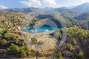 Lake in abandoned mine pit and waste heaps over mountains landscape in Xyliatos, Cyprus