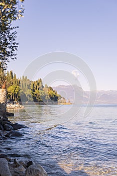Lake in the alps and a beautiful beach with trees. Travel and tourism in Europe. Free space for text