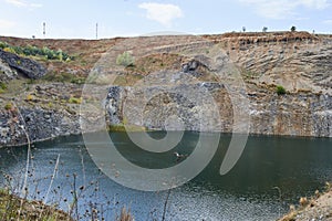 Lake in an ancient quarry with various types of rocks