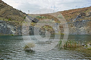 Lake in an ancient quarry with various types of rocks