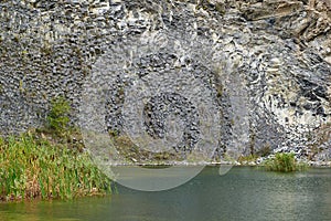 Lake in an ancient quarry with various types of rocks