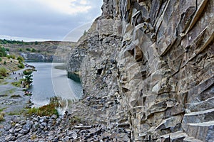 Lake in an ancient quarry with various types of rocks