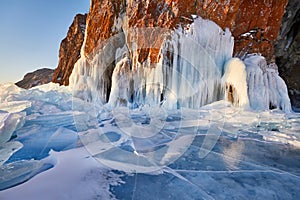 Lake Baikal is covered with ice and snow, strong cold, thick clear blue ice. Icicles hang from the rocks. Lake Baikal is a frosty