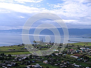 Lake Baikal. A small village on the shore. View from above. In a blue cloudy light