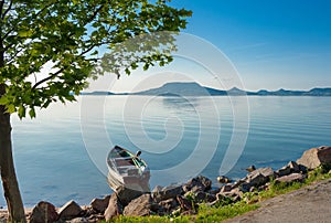 Lake Balaton with a fisher boat in the front and the Badacsonby mountain