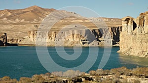 Lake basin with desert sand dunes and mountains.