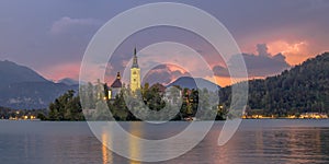 Lake bled with church under lightning stormy sky