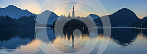 Lake Bled with St. Marys Church of Assumption on small island at night. Bled Slovenia Europe. Mountains and valley on background