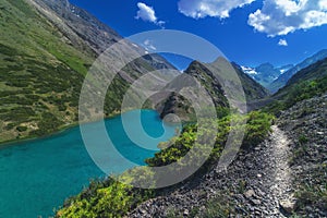 Lake with blue clear clear water in mountains in summer. Koksai Ainakol Lake in Tien Shan Mountains in Asia in