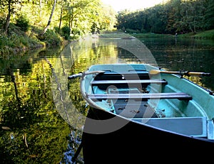 Lake with blue rowing boat and yellow reflection in the water 4