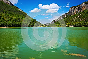 Lake and blue sky with clouds between the mountains