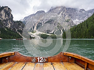 Lake Braies, Italy. POV oarsman the traditional boats made of wood. Amazing view of the famous lake Braies. Alpine lake