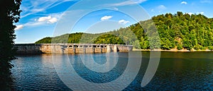 Lake Bystrzyckie located in a mountain valley, a dam on the Bystrzyca River, view from the lake shore on a sunny summer day