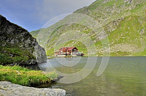 Lake cabin in the high mountains