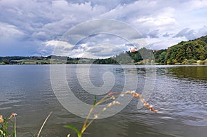 lake and Church of the Holy Trinity (Sveta Trojica) on green hills. Overcast. Slovenia