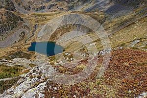 Lake Claret and La Pra mountain huts behind the rocks