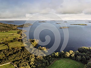 Lake Corrib, county Galway Ireland, Sunny day with cloudy blue sky and green fields separated by stone fences, islands in the lake