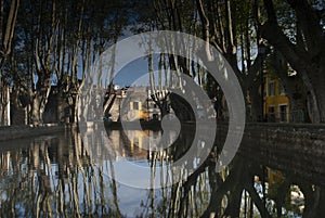 Lake in Cuceron village surrounded by trees and buildings reflecting on the water in France