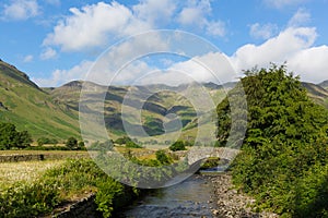 Lake District country scene mountains and river summer day Langdale Valley Mickleden Beck river Cumbria England