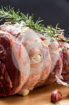 Raw rolled and tied Herdwick Sheep lamb joint prepared with garlic, rosemary and sea salt