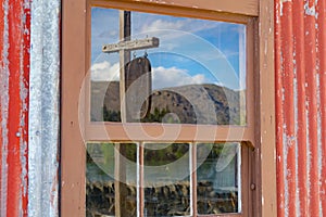 Lake Dunstan and hills around Cromwell reflected on old window gl;ass