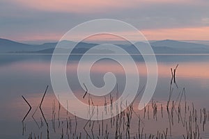 A lake at dusk, with beautiful, warm tones in the sky and water