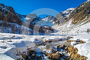 Lake Fiorenza covered with ice on the slopes of Monviso