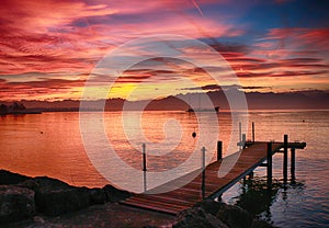 lake on fire with roman boat. Yellow, orange, red and pink plume with blue sky.